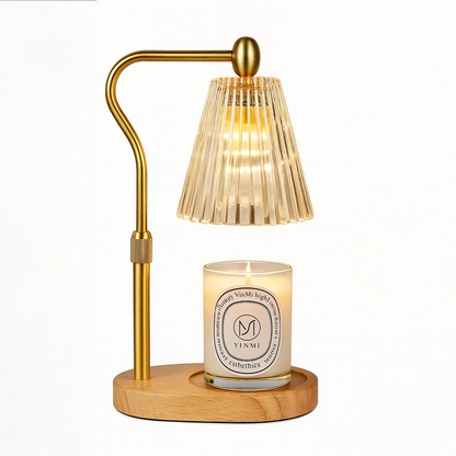 Gold candle warmer lamp with a ribbed glass shade and a lit scented candle on a wooden base, displayed on a white background.